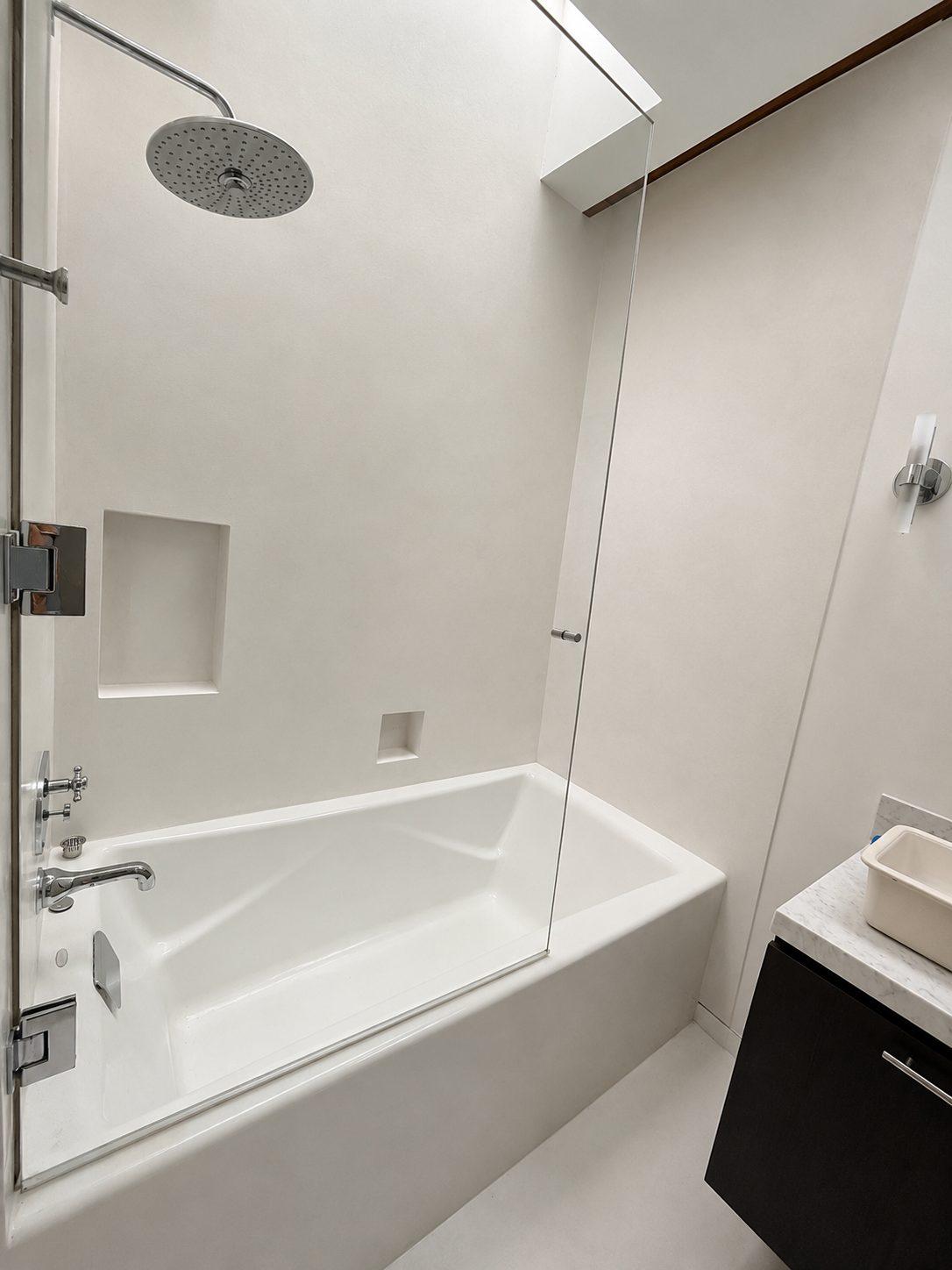 Seamless microcement bath and shower walls with formed niche in a Beverly Hills bathroom, California