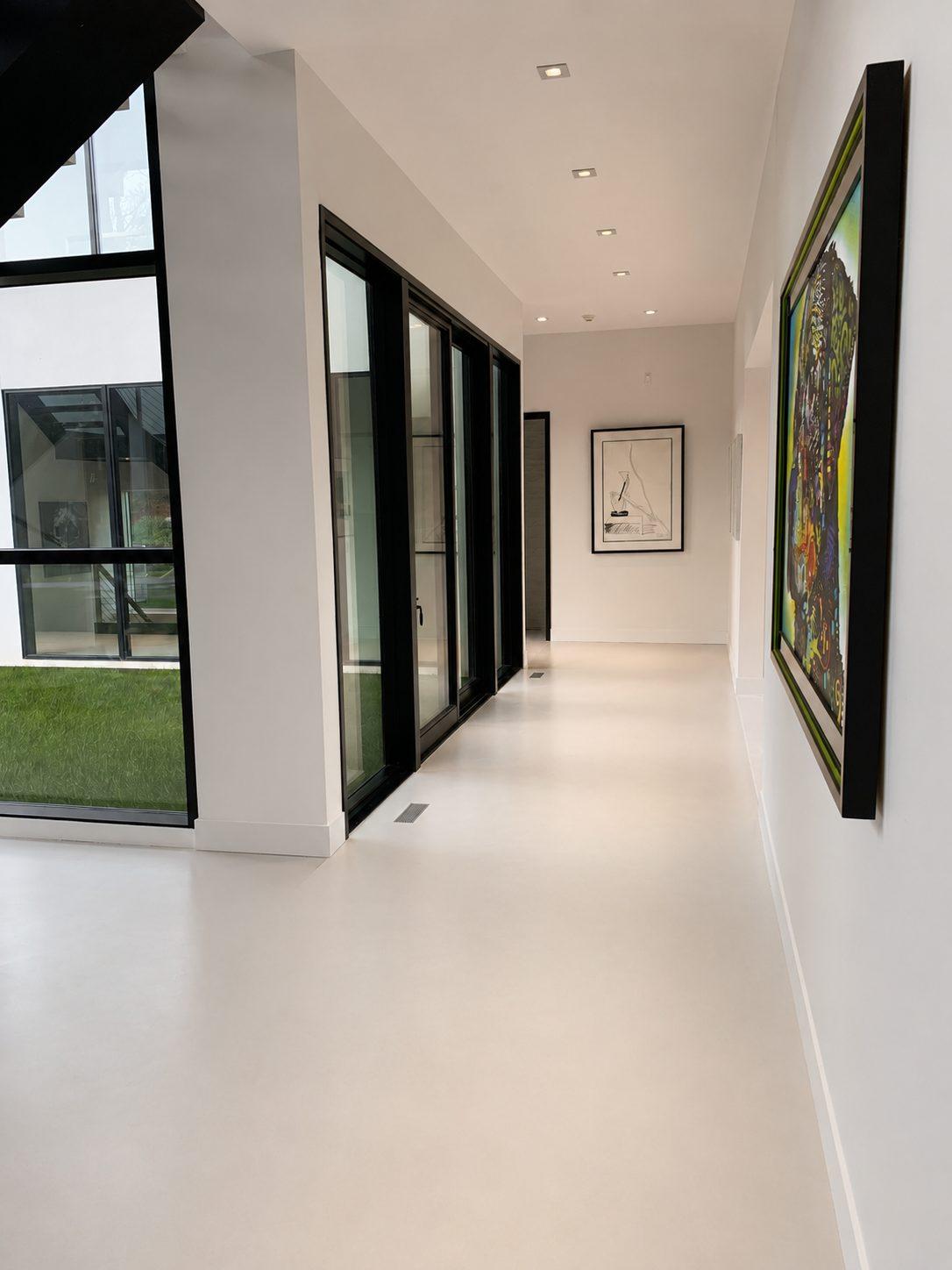 Continuous microcement floor in a gallery corridor in Sands Point, Long Island