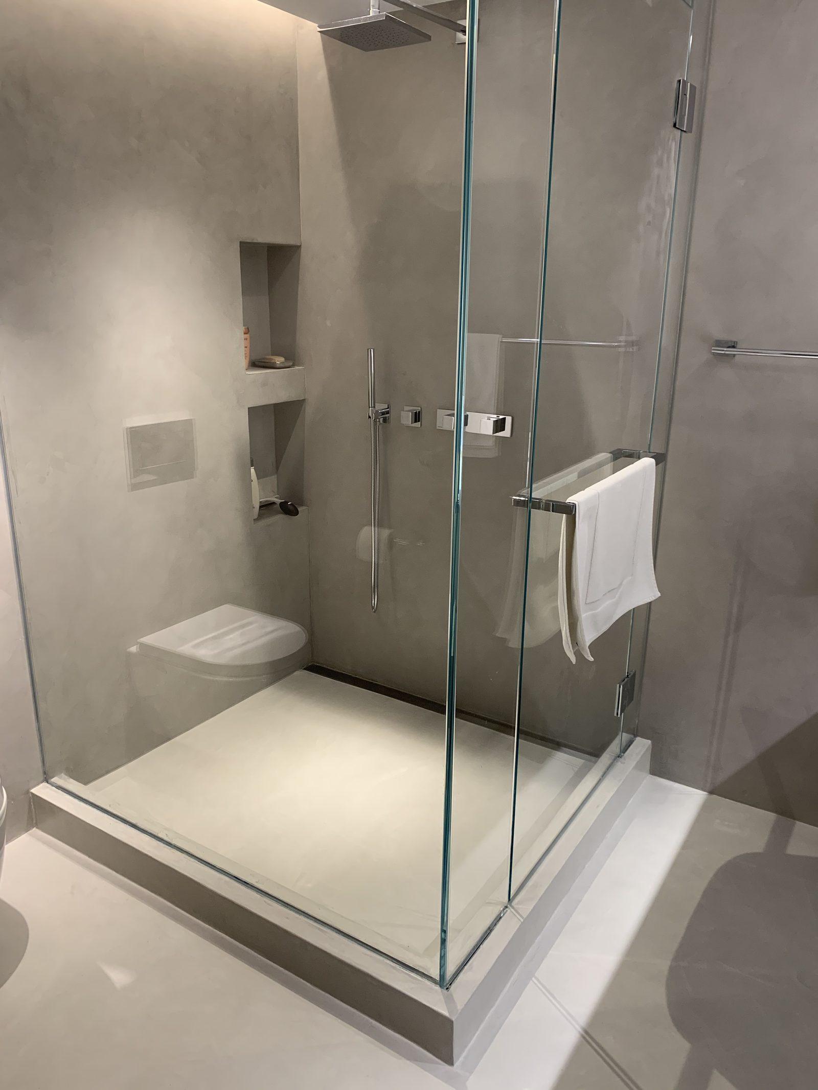 Microcement walk-in shower with seamless walls, niches and shower tray in a Manhattan apartment