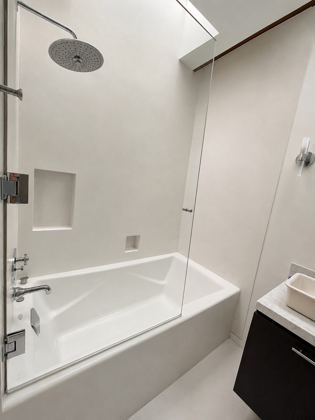 Seamless microcement bath and shower walls with formed niche in a Beverly Hills bathroom, California
