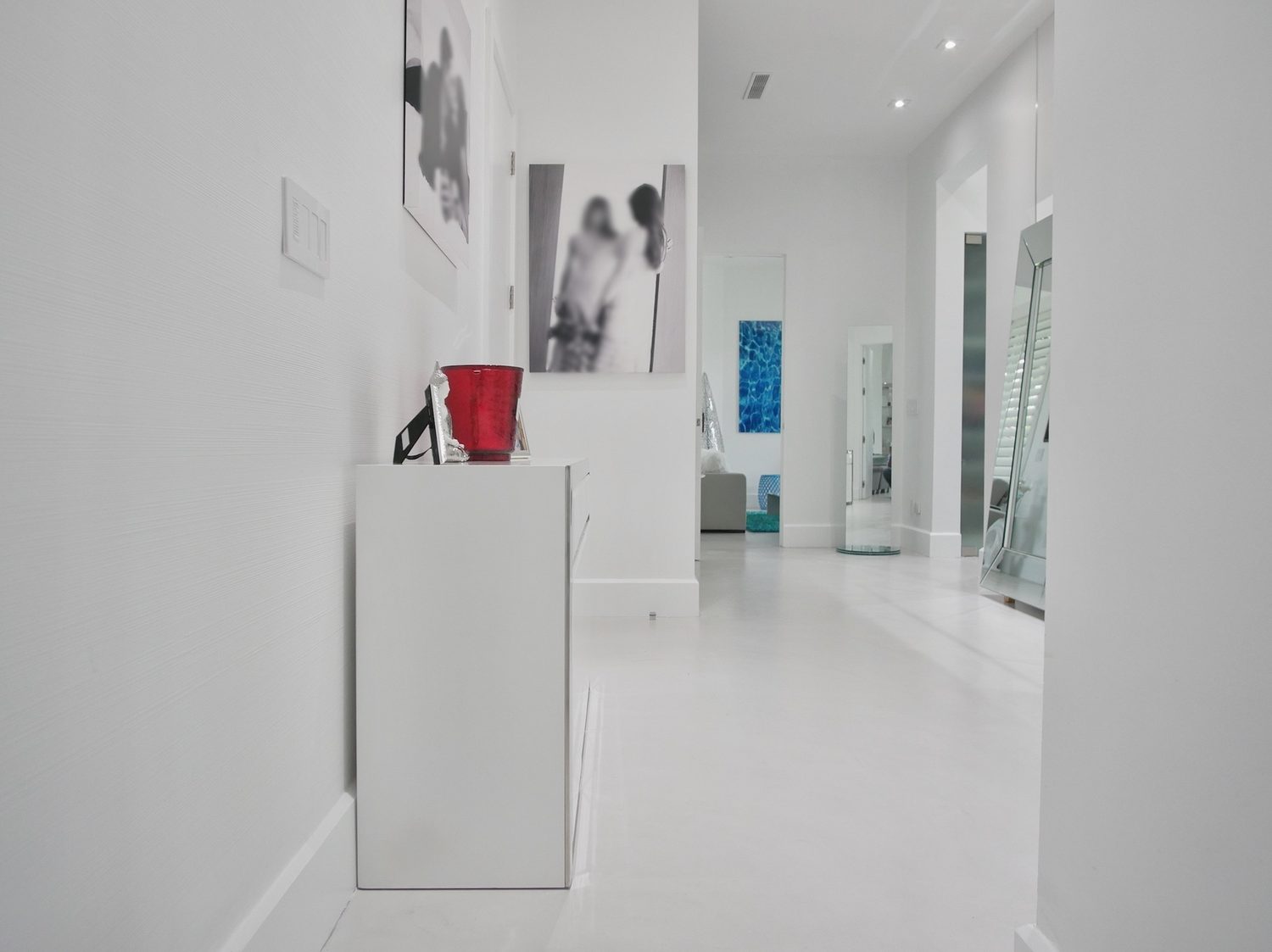 Continuous white microcement floor running through a hallway and living area in an Avalon residence, New Jersey