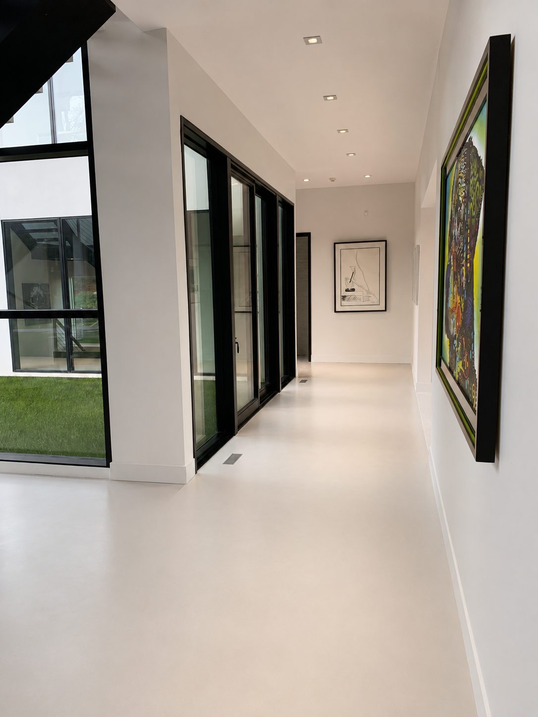 Continuous microcement floor in a gallery corridor in Sands Point, Long Island