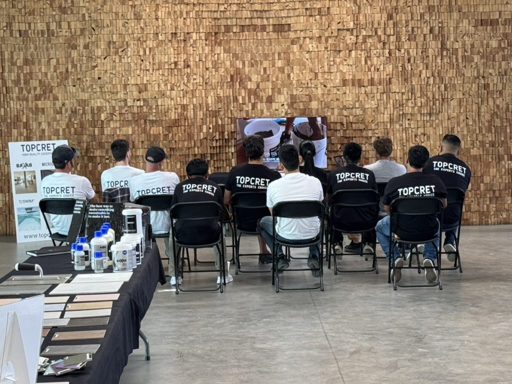 Trainees watching a live microcement demonstration at a Topcret course
